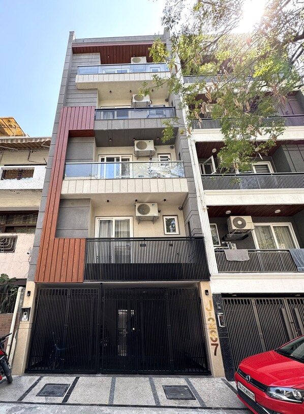 A multi-story residential building with balconies, air conditioning units, and a gated entrance. - Fortune Home Service Apartment Studio, J-267 Saket (New Delhi)