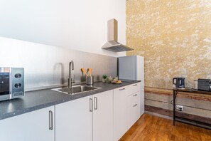 A modern kitchen with a stainless steel range hood, a built-in oven, and a granite countertop. - iFlat | Charming Historic Palace Fons Trevi B15 (Rome)