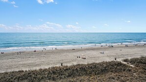 A beach with people, a clear sky, and the ocean. - Sea Winds #502-Oceanfront Oasis with Indoor Pool! In Windy Hill - NMB! (North Myrtle Beach)