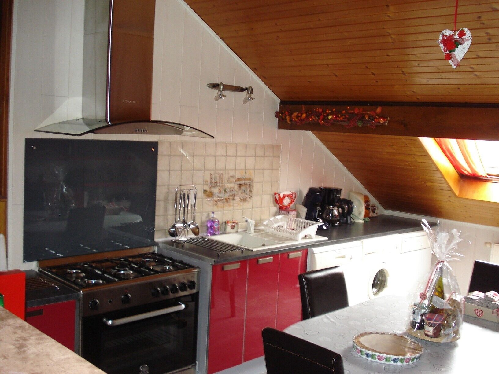 A kitchen with a stove, oven, and red cabinets.
