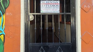 A black metal gate with a sign indicating rentable studios, a number 1438, and a WhatsApp contact number. - Modern and Cozy Rustic Loft (Puerto Vallarta)