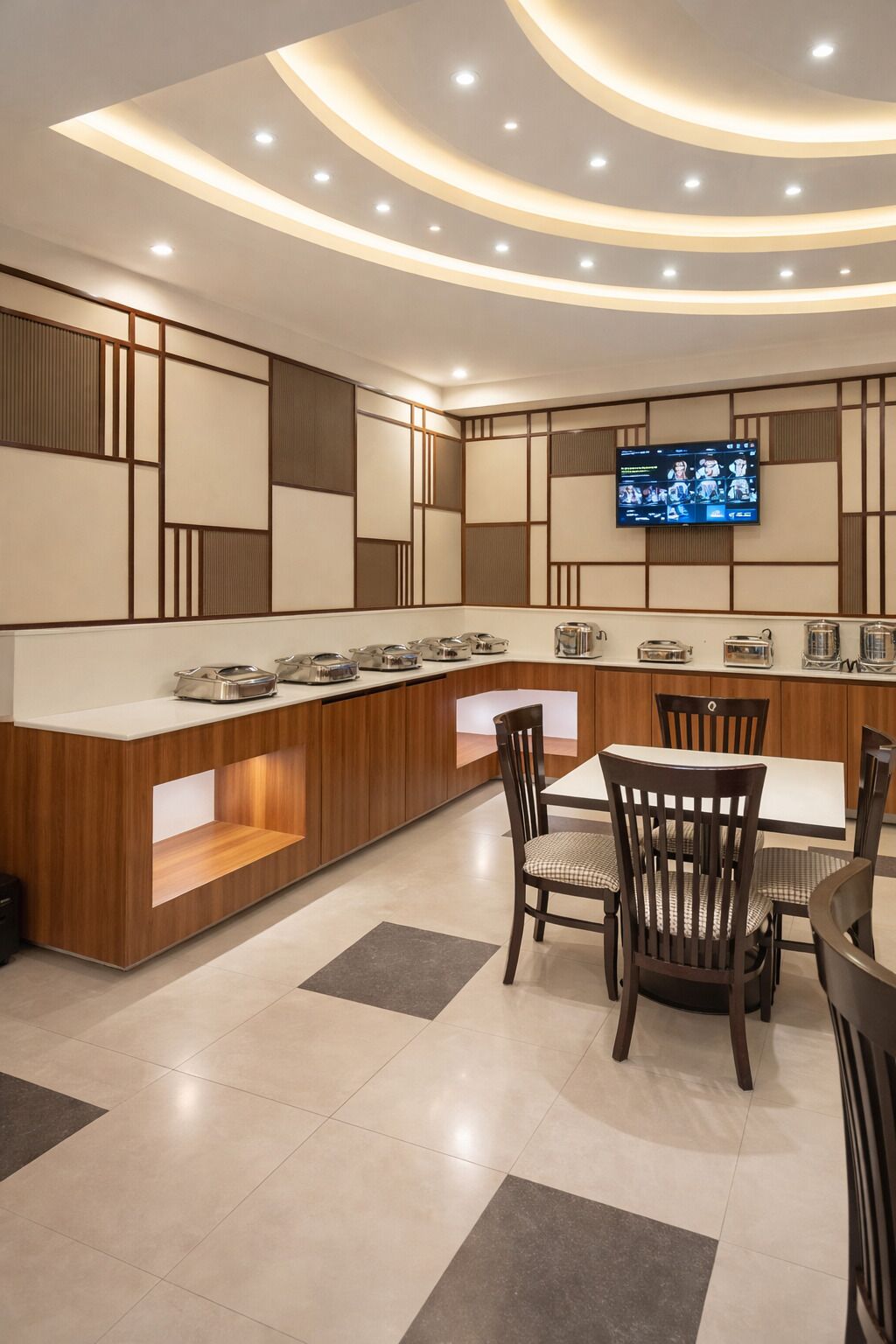 A modern kitchen with a wooden counter, built-in appliances, and a flat-screen TV mounted on the wall.