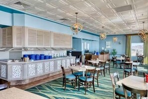 Ein Restaurant mit Barbereich, mehreren Tischen, Stühlen und einem gemusterten Teppich.