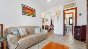Un salon avec un canapé, une table basse et une cheminée.