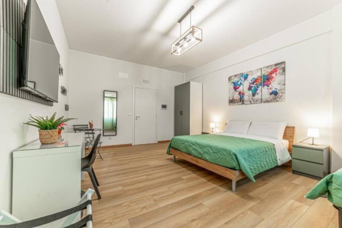 Ein modernes Schlafzimmer mit Bett, Nachttischen, Schreibtisch und Stuhl.