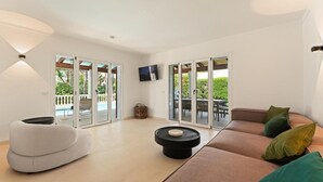Ein modernes Wohnzimmer mit einer Couch, einem runden Couchtisch und einem Fernseher.
