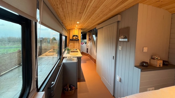 A modern interior with a kitchen area, a dining space, and a large window offering a view of the outdoors. - No 1 The Depot (Gateshead)