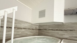 A modern bathroom with a freestanding bathtub, a shower area, and a small window. - The Little Penthouse is a charming two-level condo located in the gated Southwood Shores. This comfortable retreat offers access to resort style amenities including indoor and outdoor pools, a hot tub, playground, swimming area. (Lake Ozark)