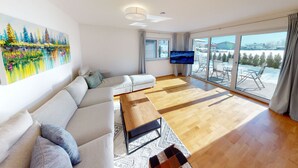 Una sala de estar moderna con un sofá, una mesa de centro y un televisor.