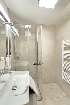 A modern bathroom with a glass-enclosed shower, a white sink, and a towel rack. - 3_SPA - Junior Suite 208 by Interhome (Zell am See)