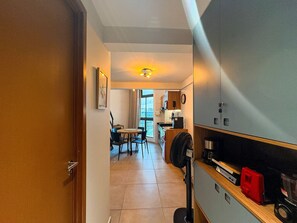 A compact kitchen with a dining area, a fan, and a clock on the wall. - Max Carneiros Suites - Praia dos Carneiros by CTA (Tamandaré)