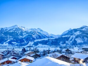 Ein Bergdorf mit schneebedeckten Häusern und freiem Blick auf die umliegenden Berge.