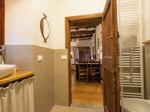 Een badkamer met een houten wastafelmeubel, een wastafel en een douche.