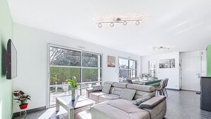 Ein geräumiges Wohnzimmer mit einer Sofagarnitur, einem Couchtisch und einem Essbereich mit Stühlen.