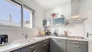 Eine moderne Küche mit Fenster, Einbauküche, Spüle und Herd.
