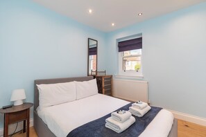 Ein Schlafzimmer mit einem Bett, einem Nachttisch, einem Fenster mit Blick und einer Heizung.