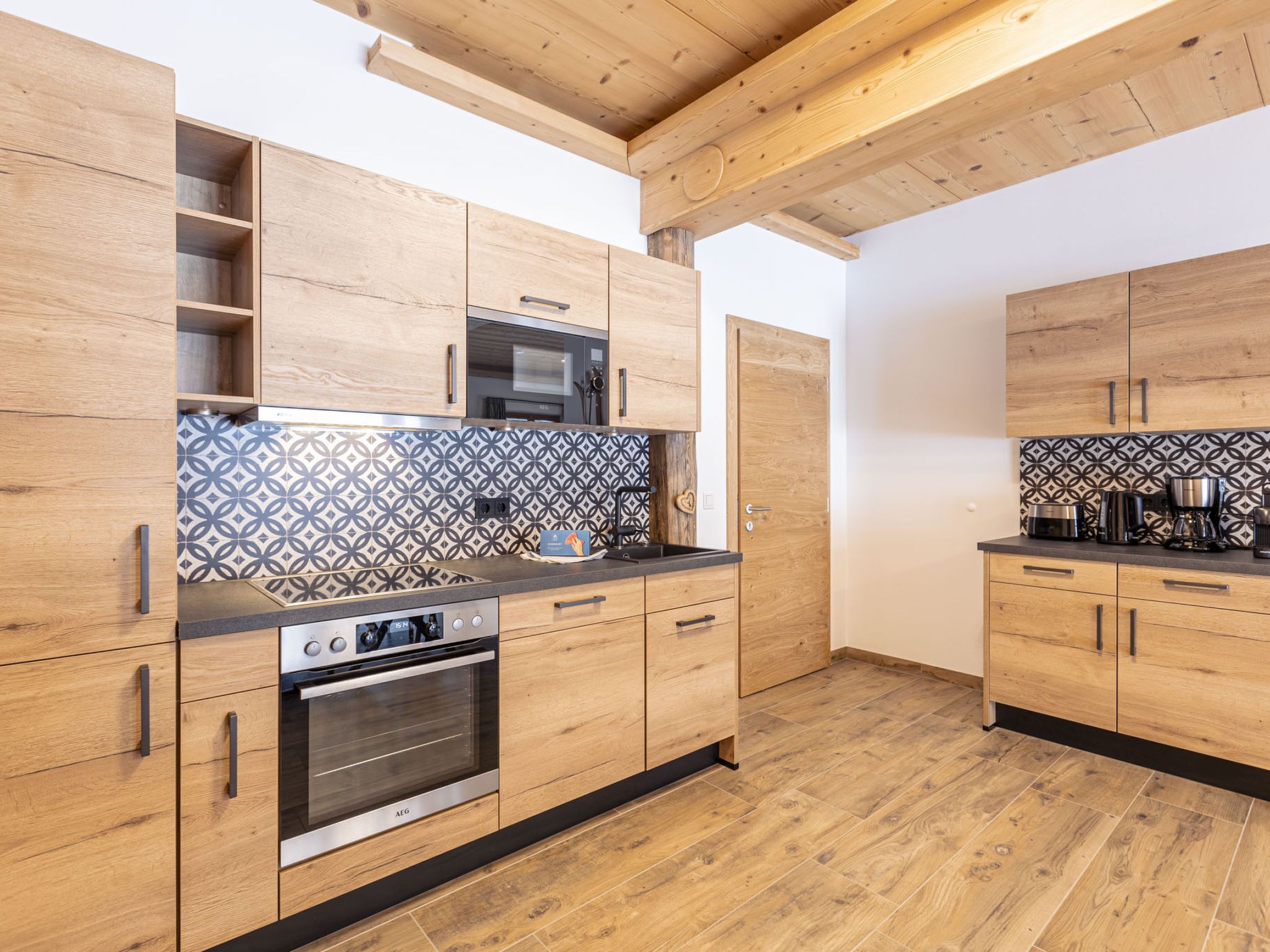 A modern kitchen with wooden cabinets, a patterned backsplash, and a built-in oven.