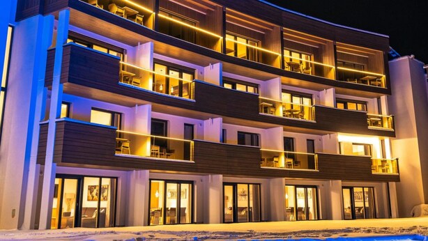 A multi-story hotel with balconies, a swimming pool, and a modern architectural design. - 3_SPA Panorama MAX 205 by Interhome (Zell am See)