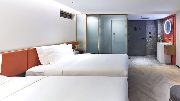 A modern hotel room with a large bed, a desk, and a bathroom with a mirror. - Life Style  (Douala)