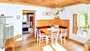 Un interior de madera con una mesa de comedor, sillas, un banco y techo de madera.