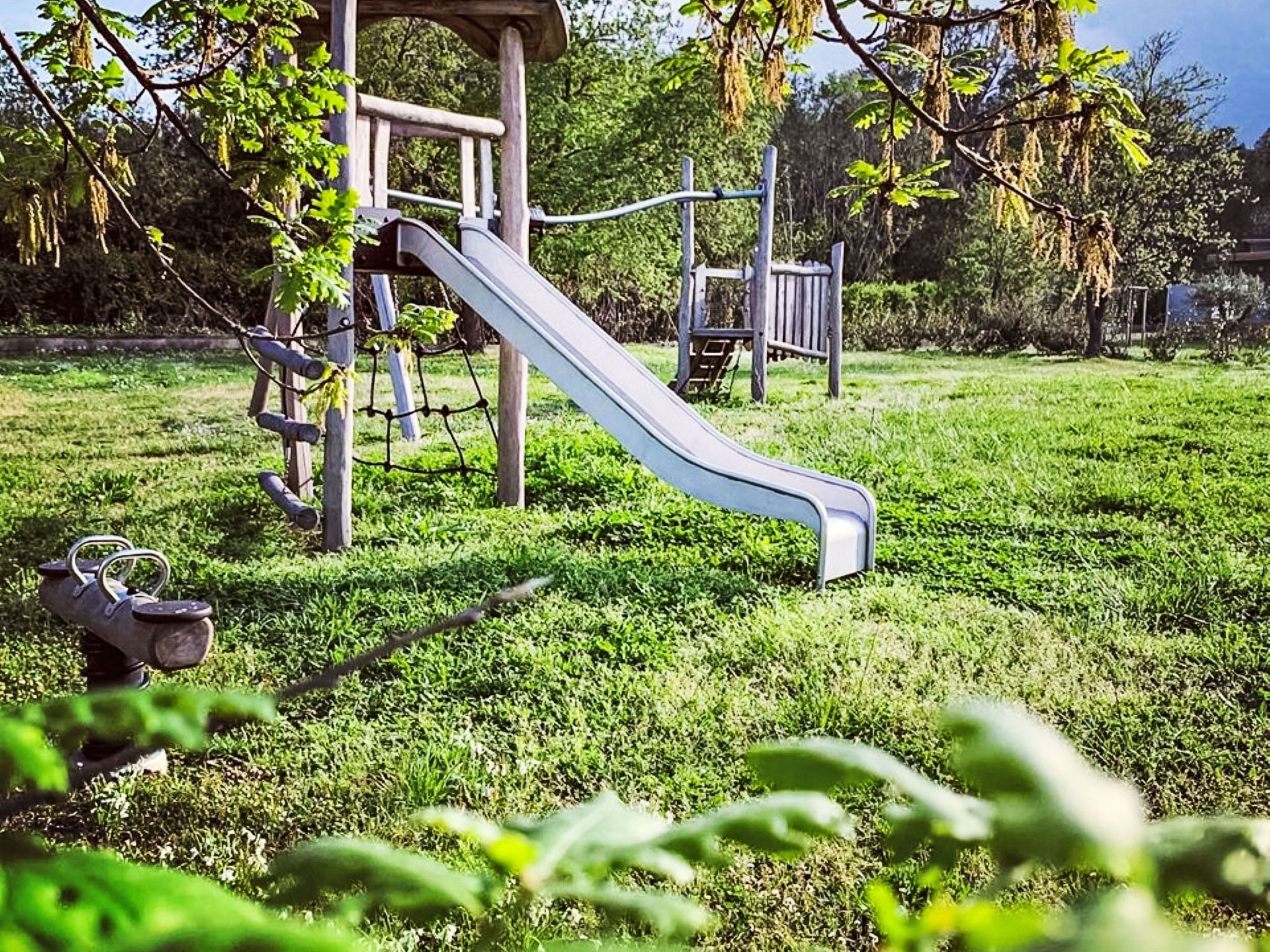 Un patio de juegos con un tobogán y estructuras para escalar.