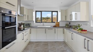 Uma cozinha moderna com forno embutido, micro-ondas e exaustor de aço inoxidável.