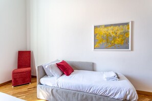 A modern room with a grey sofa, red chair, and a painting on the wall. - iFlat | Classic roman palazzo Fons Trevi A15 (Rome)