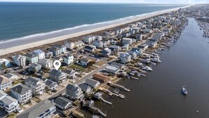 Vista aérea de una zona residencial costera con casas, un puerto deportivo y una playa.