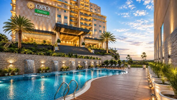 A hotel with a swimming pool, outdoor staircase, and a view of the city. - OPO Premier MARVEL (Jaipur)