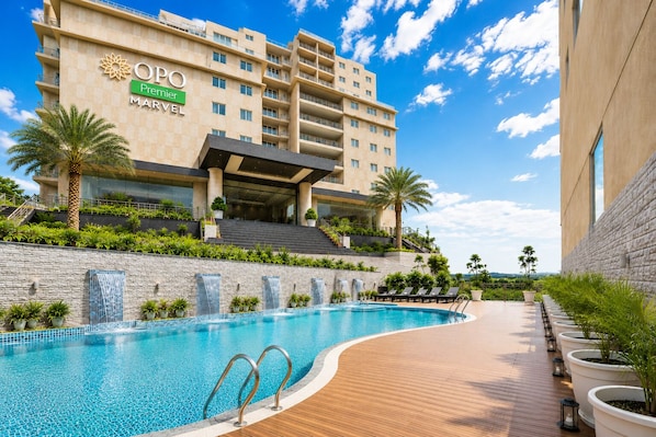 Un hotel con piscina, zona de estar al aire libre y vistas del paisaje circundante.