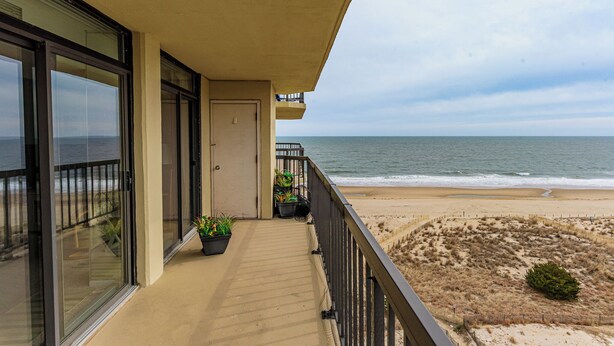 Un balcon avec vue sur la plage et l’océan.