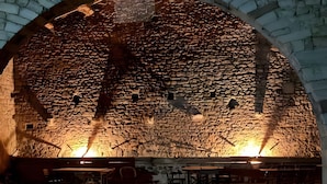 Un interior con paredes de piedra, una mesa de madera y sillas.
