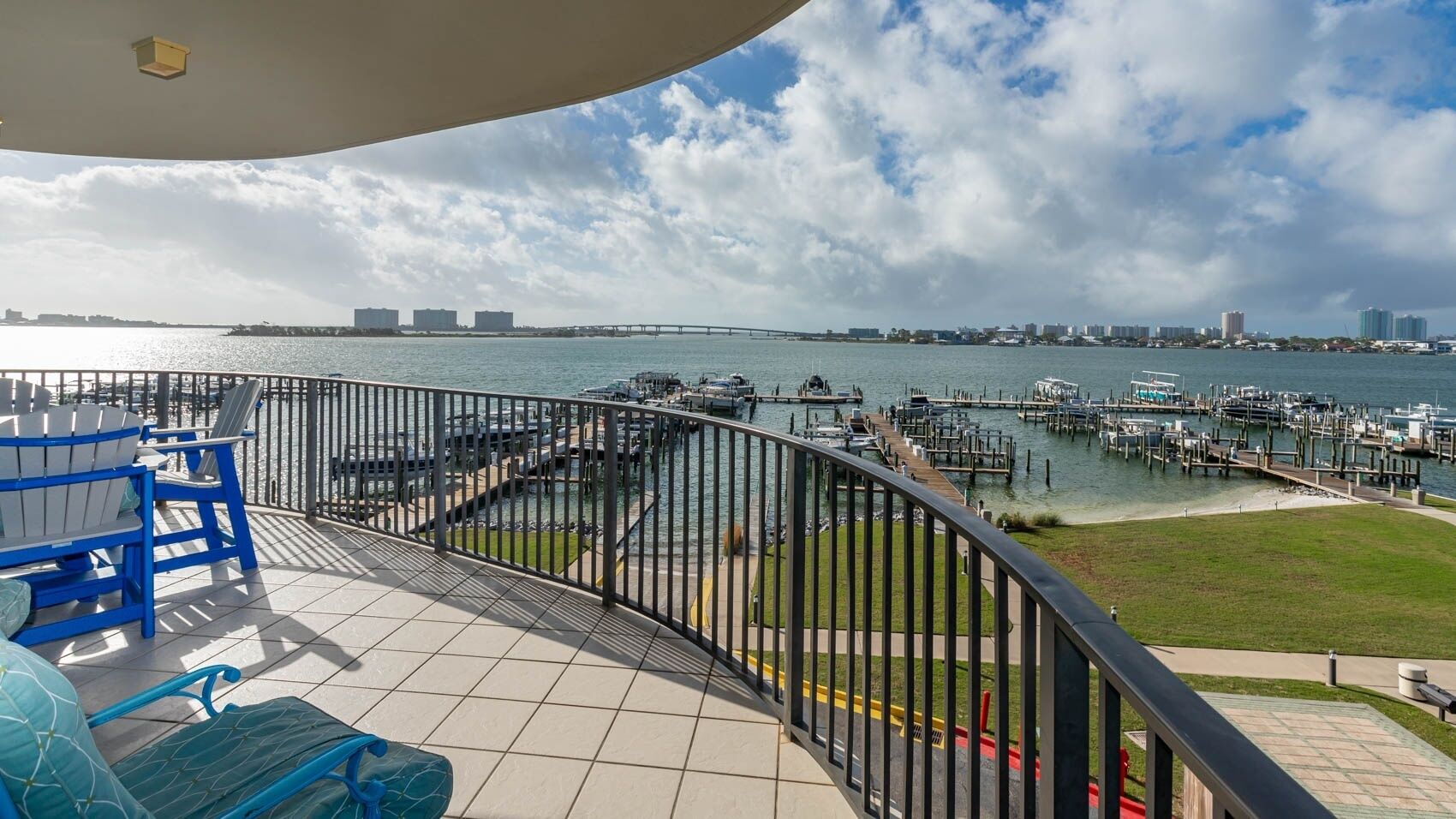 Een balkon met uitzicht op een jachthaven en de stadshemel.