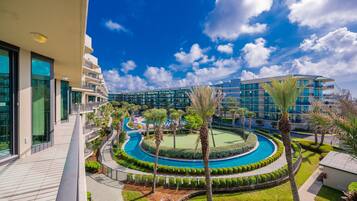 A resort with a pool, palm trees, and modern buildings.