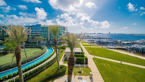 A hotel with a pool, palm trees, and a marina. - Phoenix On The Bay 1303 3 Bedroom Condo (Orange Beach)