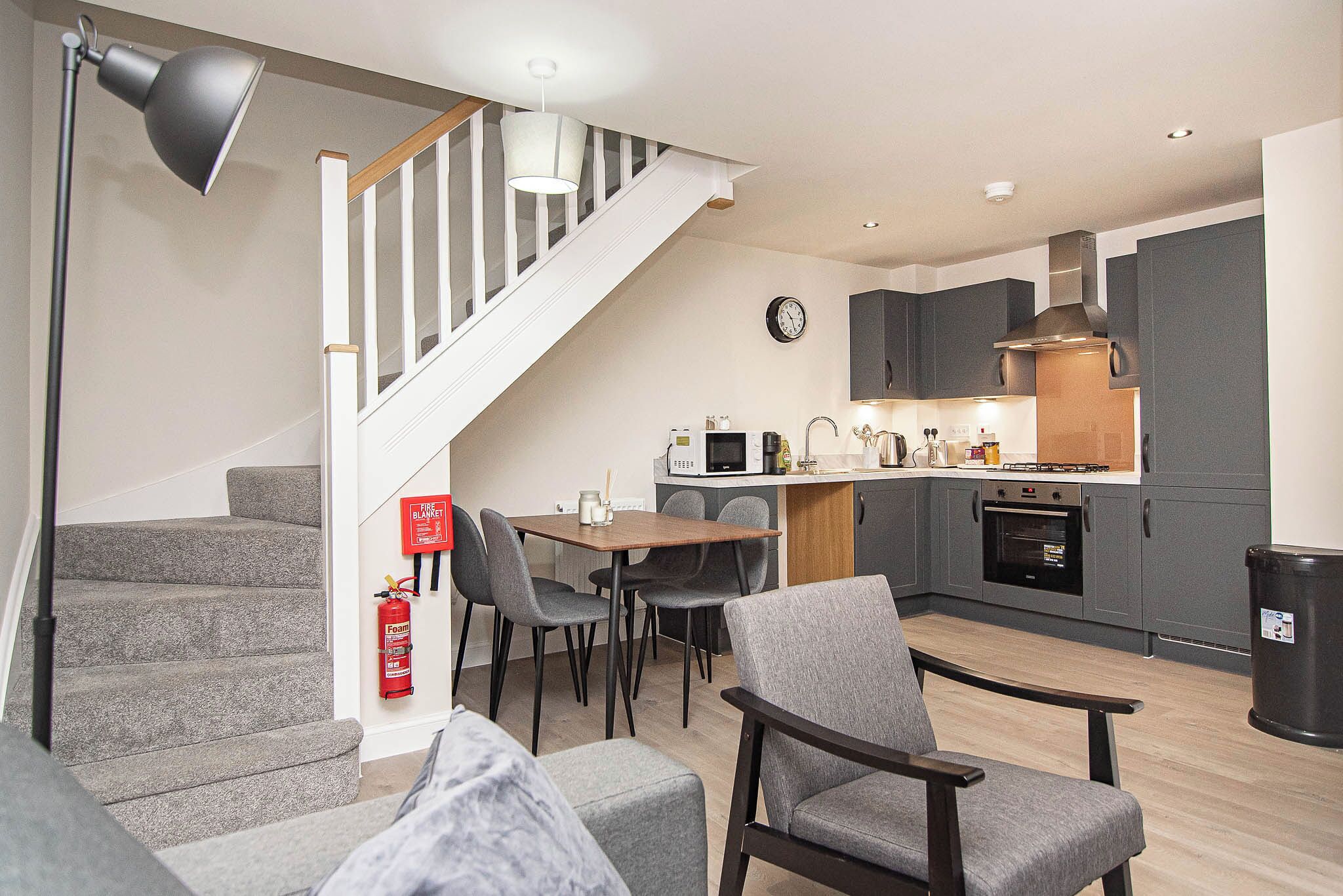 Eine moderne Wohnung mit Treppe, Essbereich, Küche und Wohnzimmer.