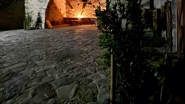 Un bâtiment en pierre doté d’une grande entrée en arc de cercle et d’une petite fenêtre.