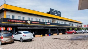 Un hotel con un letrero que dice 'Hotel Flor de Lotus' y una tienda de conveniencia.