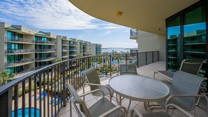 Un balcón con vistas a una piscina y edificios cercanos.