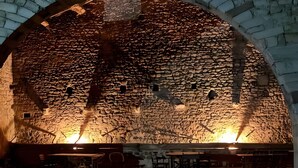 Un intérieur avec des murs en pierre, une table en bois et des chaises.
