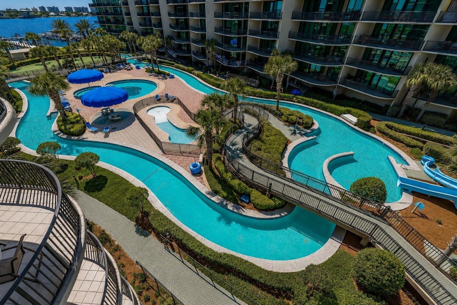 Ein Resort mit mehreren Schwimmbecken, einer Wasserrutsche und Blick auf den Ozean.