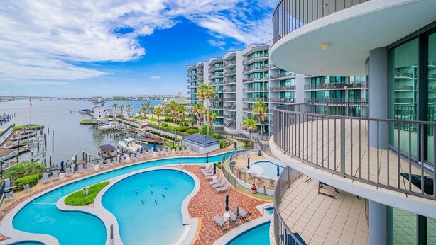 A hotel with a swimming pool, a marina, and a view of the water. - Lighthouse On The Bay 2413 3 Bedroom Condo (Orange Beach)