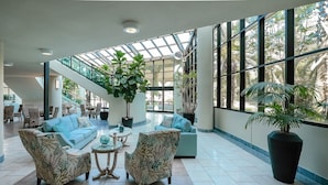 A spacious lobby with a high ceiling, large windows, and a central staircase. - Phoenix On The Bay 1129 2 Bedroom Condo (Orange Beach)