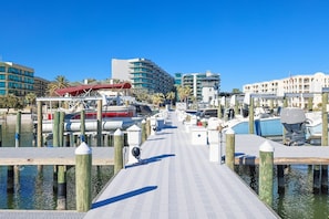 A marina with docked boats, wooden pilings, and buildings in the background. - Lighthouse On The Bay 2509 3 Bedroom Condo (Orange Beach)