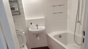 A bathroom with a toilet, sink, and bathtub.