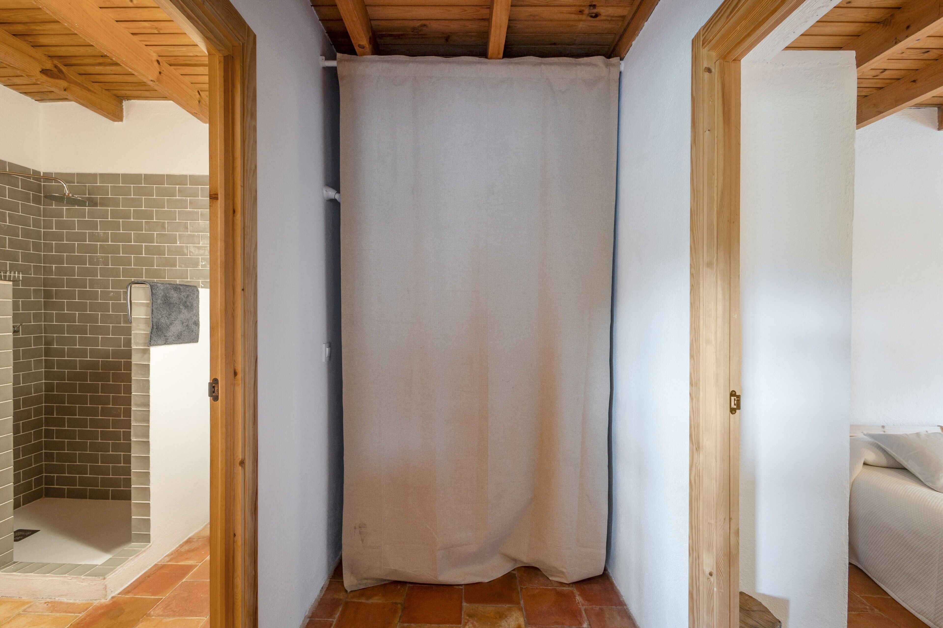 Ein Badezimmer mit Dusche, Vorhang und Holzboden.