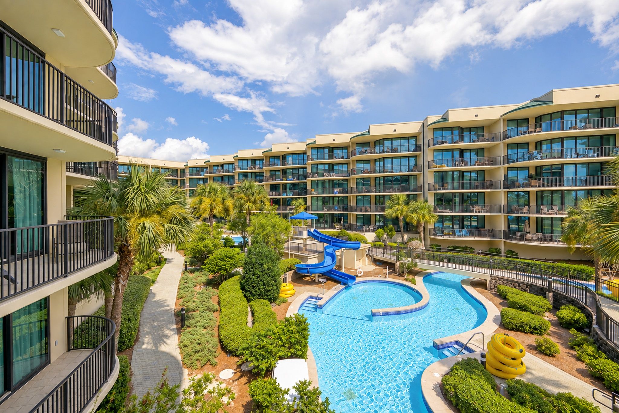 A resort with a swimming pool, water slides, and multiple balconies.