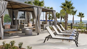 A rooftop lounge area with seating, umbrellas, and palm trees. - 705 Margate, 3 bedroom ocean front condo 3 Condo (Myrtle Beach)