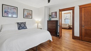 Una camera da letto con un letto, una cassettiera e opere d'arte appese al muro.