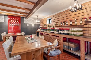 Ein Restaurant mit Holztisch, Stühlen und einer Weinwand.